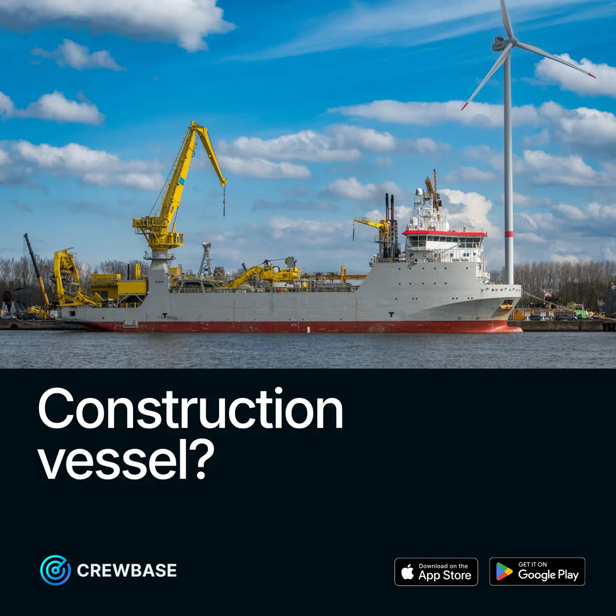 Offshore construction vessel with crane and wind turbine in harbour with CrewBase construction vessel recruitment ad